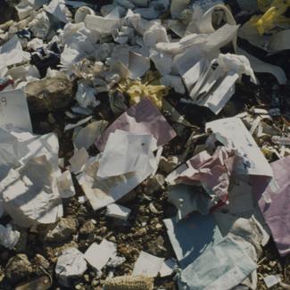 Tvornička korispodencija - papir na otpadu pored tvorničkog zida 