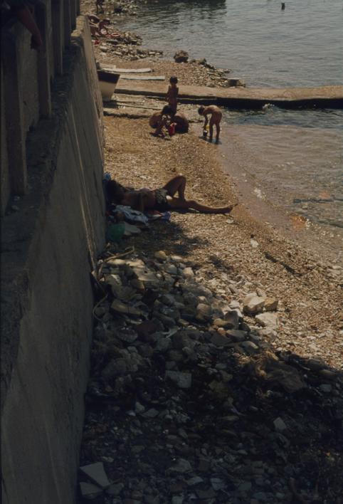 Kupači ispred žute kuće; JNA 12, pored smeća